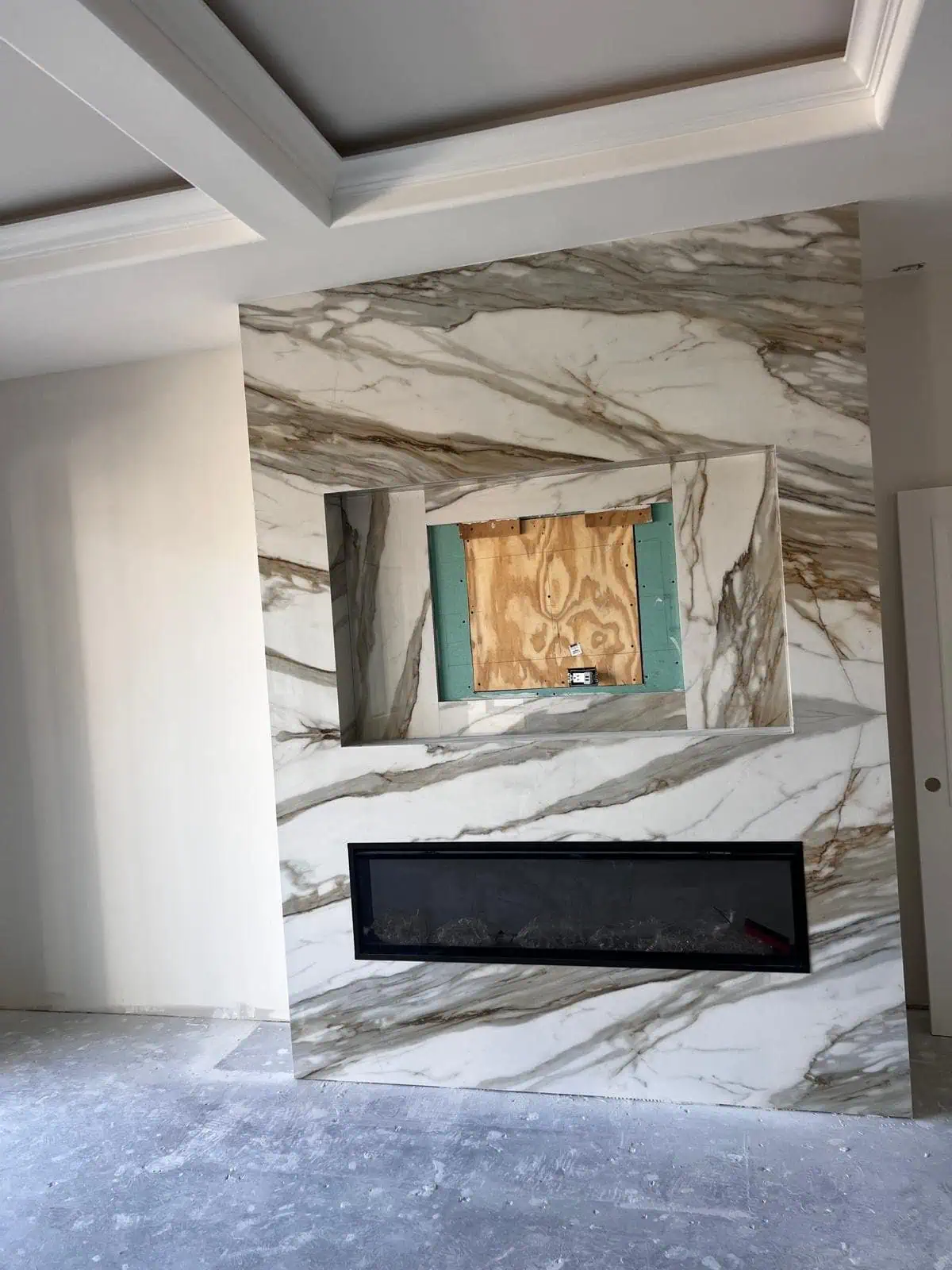 Modern marble fireplace with built-in space for a TV or artwork.