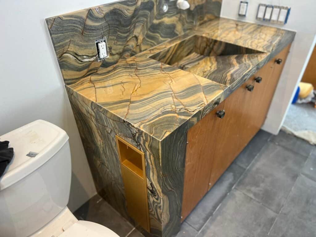 Polished stone bathroom vanity with a striking multicolored marble pattern.