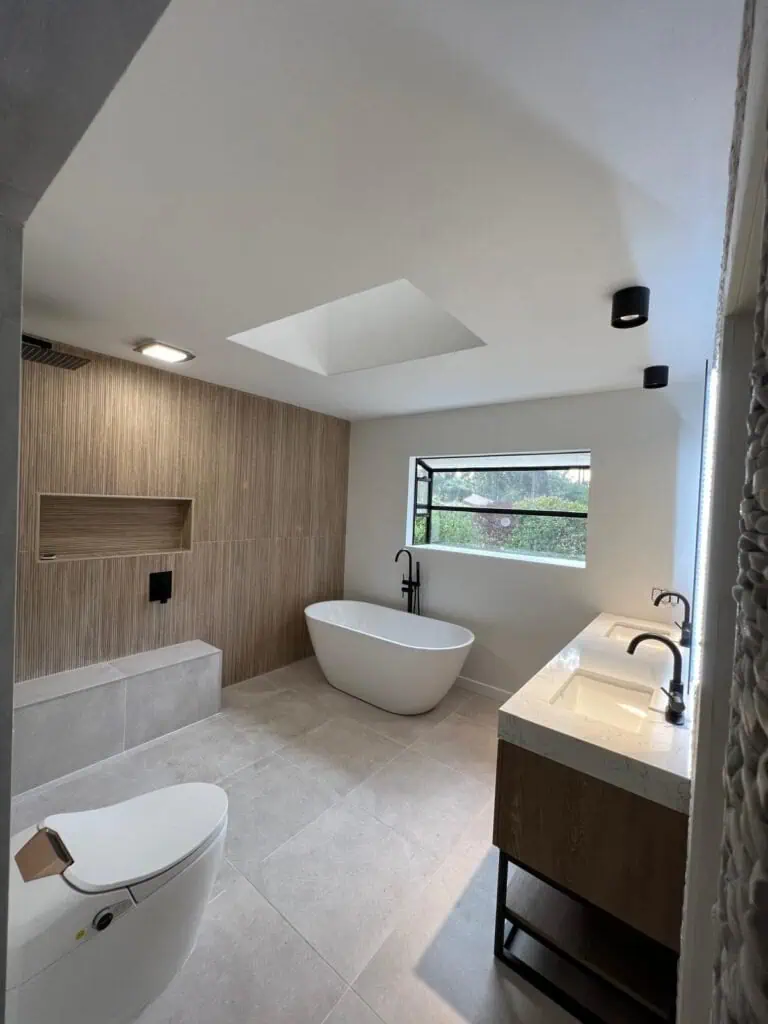 Modern bathroom with freestanding tub, double vanity, and natural light in a contemporary home.