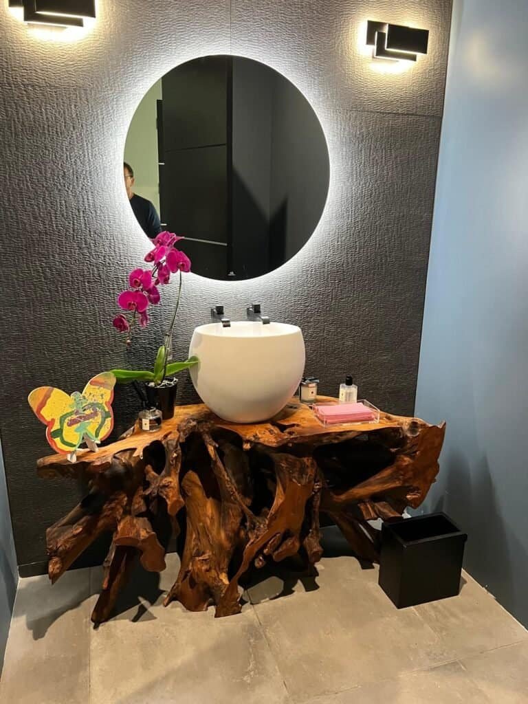 Elegant bathroom vanity with a unique wooden countertop and modern sink setup.